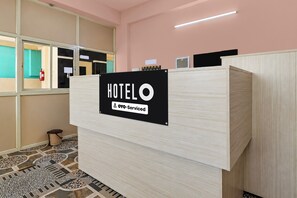 Mostrador de recepción de hotel con un cartel que indica que es atendido por OYO.