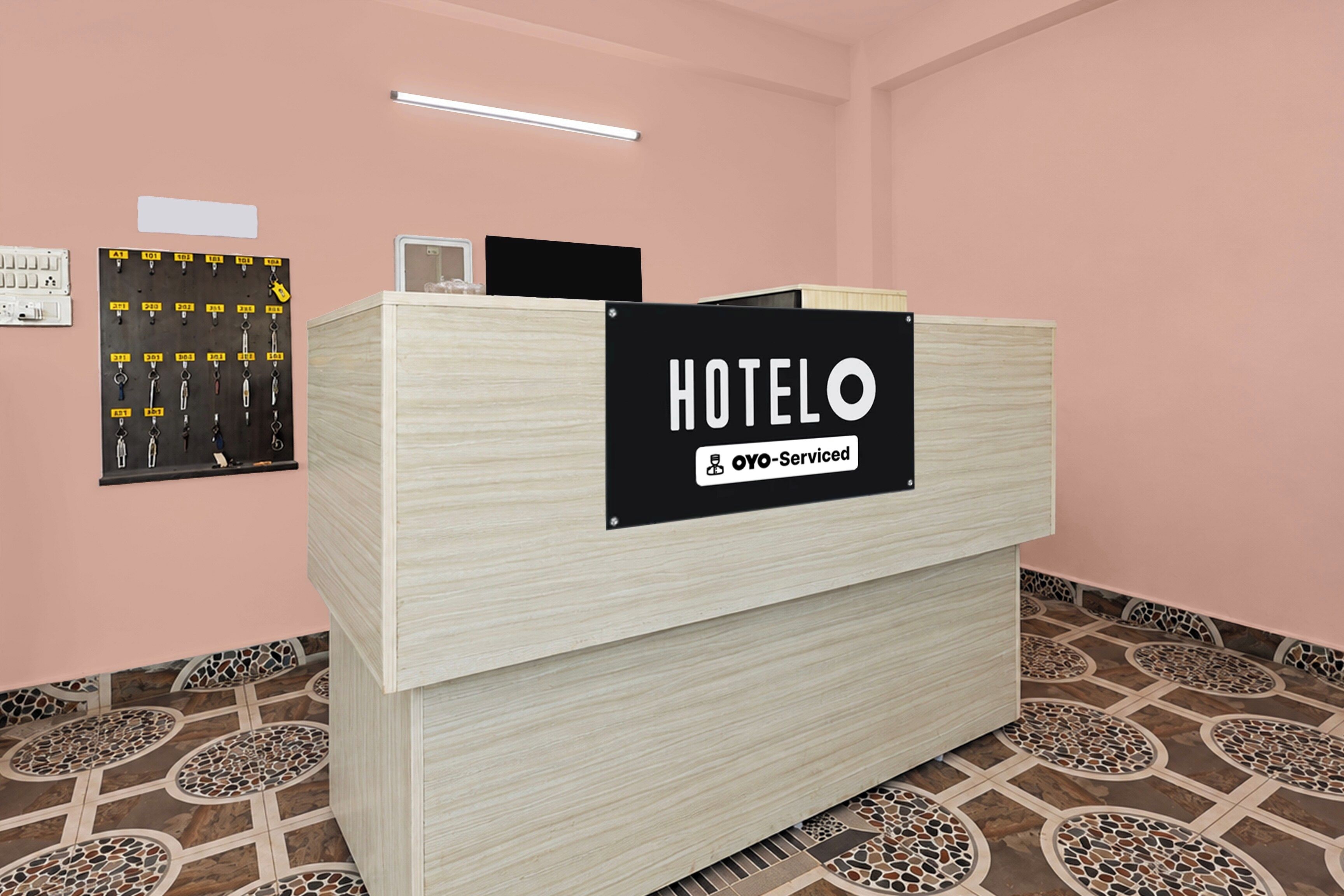 Un comptoir d’accueil d’hôtel avec une pancarte indiquant que l’établissement est géré par OYO.