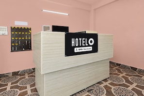Mostrador de recepción de hotel con un letrero que indica que es administrado por OYO.