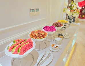 Ein reichhaltiges Buffet mit verschiedenen Früchten und einer dekorativen Vase.