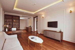 A modern living room with a sofa, coffee table, TV, and a wooden cabinet.