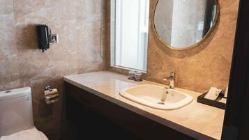 Une salle de bain avec des toilettes, un lavabo et un miroir.