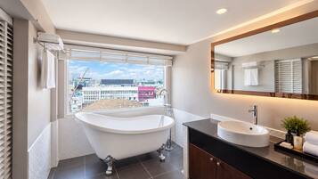 A modern bathroom with a freestanding bathtub, a vanity with a sink, and a large mirror.
