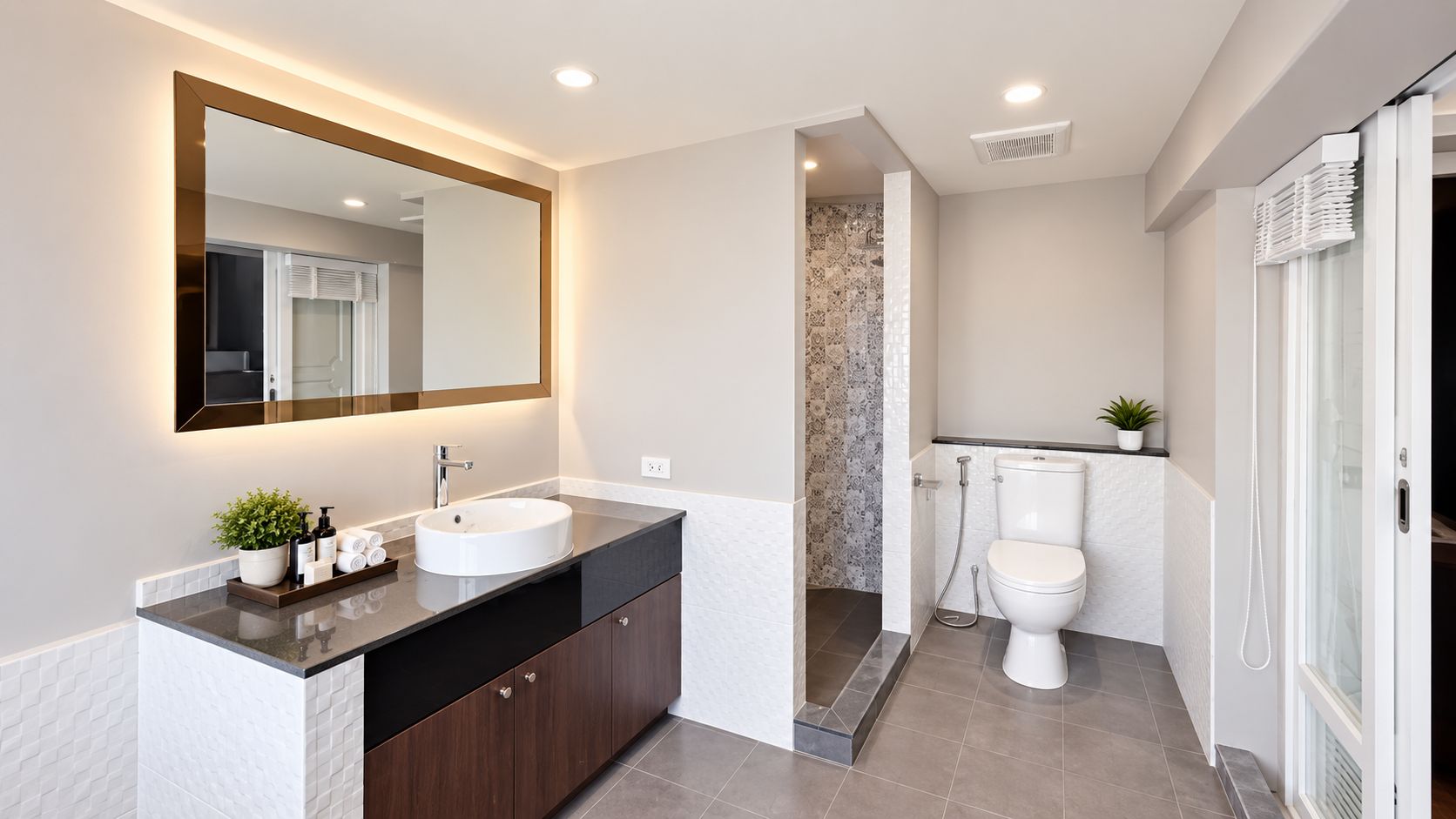 A modern bathroom with a large mirror, a round sink, and a toilet.