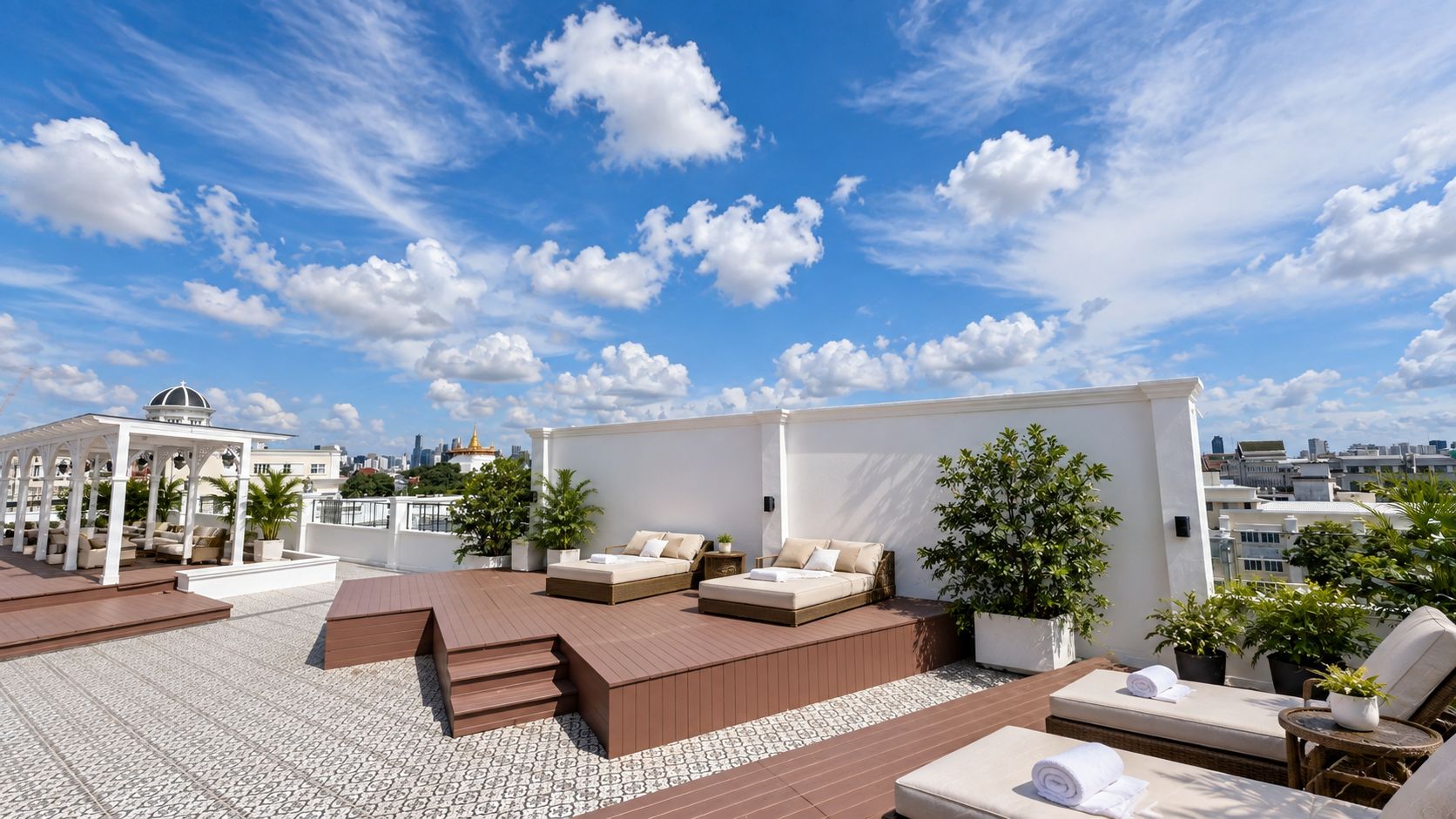 A rooftop terrace with outdoor seating, a sun lounge, and potted plants.