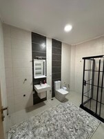 Un baño con lavamanos blanco, inodoro y cabina de ducha.