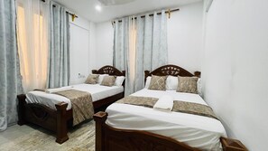 A hotel room with two wooden beds, white linens, and light-colored curtains. - 2-Bed AC Apartment
Pool & Ocean Breeze
Nyali, Mombasa
Sleeps 6 (Nyali)