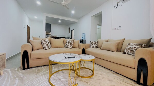 A modern living room with a beige sectional sofa, two marble coffee tables, and a ceiling fan. - 2-Bed AC Apartment
Pool & Ocean Breeze
Nyali, Mombasa
Sleeps 6 (Nyali)