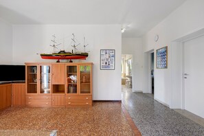 A living room with a wooden cabinet, a television, and a model ship on top. - Apartment 'La Prua - Capitan Libeccio' with Lake View, Wi-Fi, and Air Conditioning (Garda)