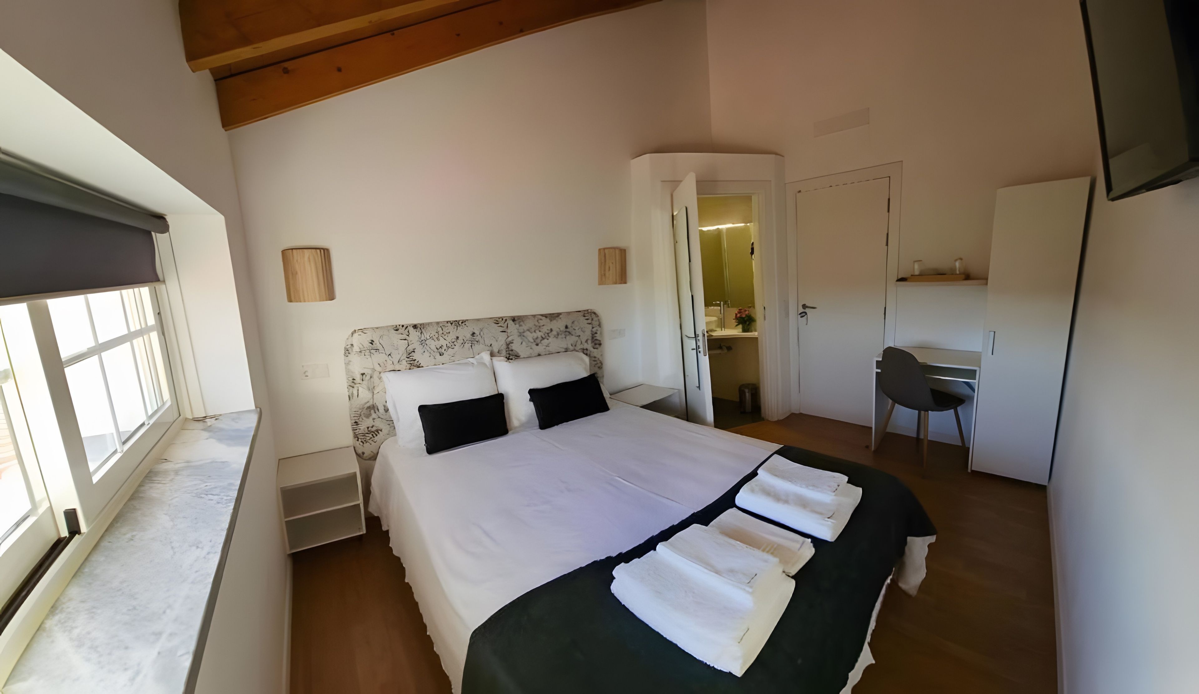 Une chambre à coucher avec un lit, un bureau et une chaise.