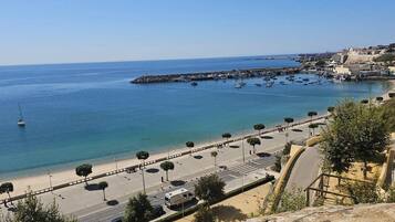 A coastal road with a beach and a marina.