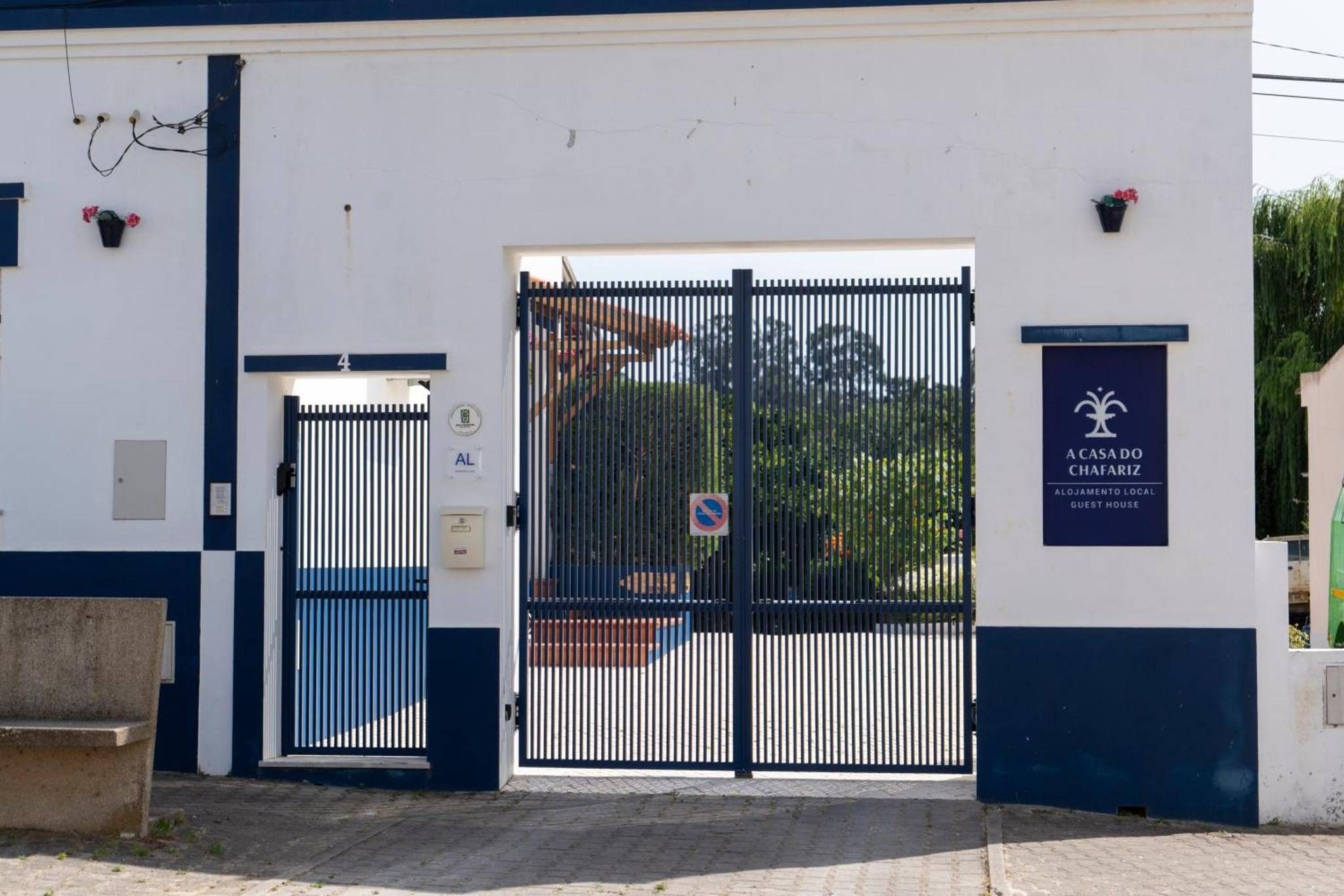 A gated entrance to a building with a sign indicating it is a guest house.