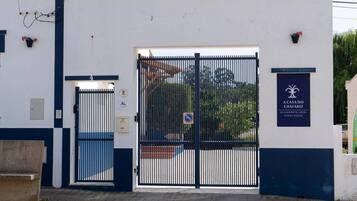 A gated entrance to a building with a sign indicating it is a guest house.