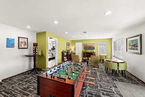 A room with a foosball table, chairs, a fireplace, and artwork on the walls. - 2x2BR Condos, Winter Escape Near the Mountains (Leavenworth)