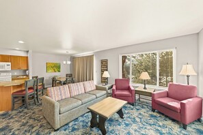 A living room with a sofa, two armchairs, a coffee table, a dining area with chairs, a kitchen area, and a large window with blinds. - 3x 2BR Condos: 1 mile to Christmas Lights (Leavenworth)