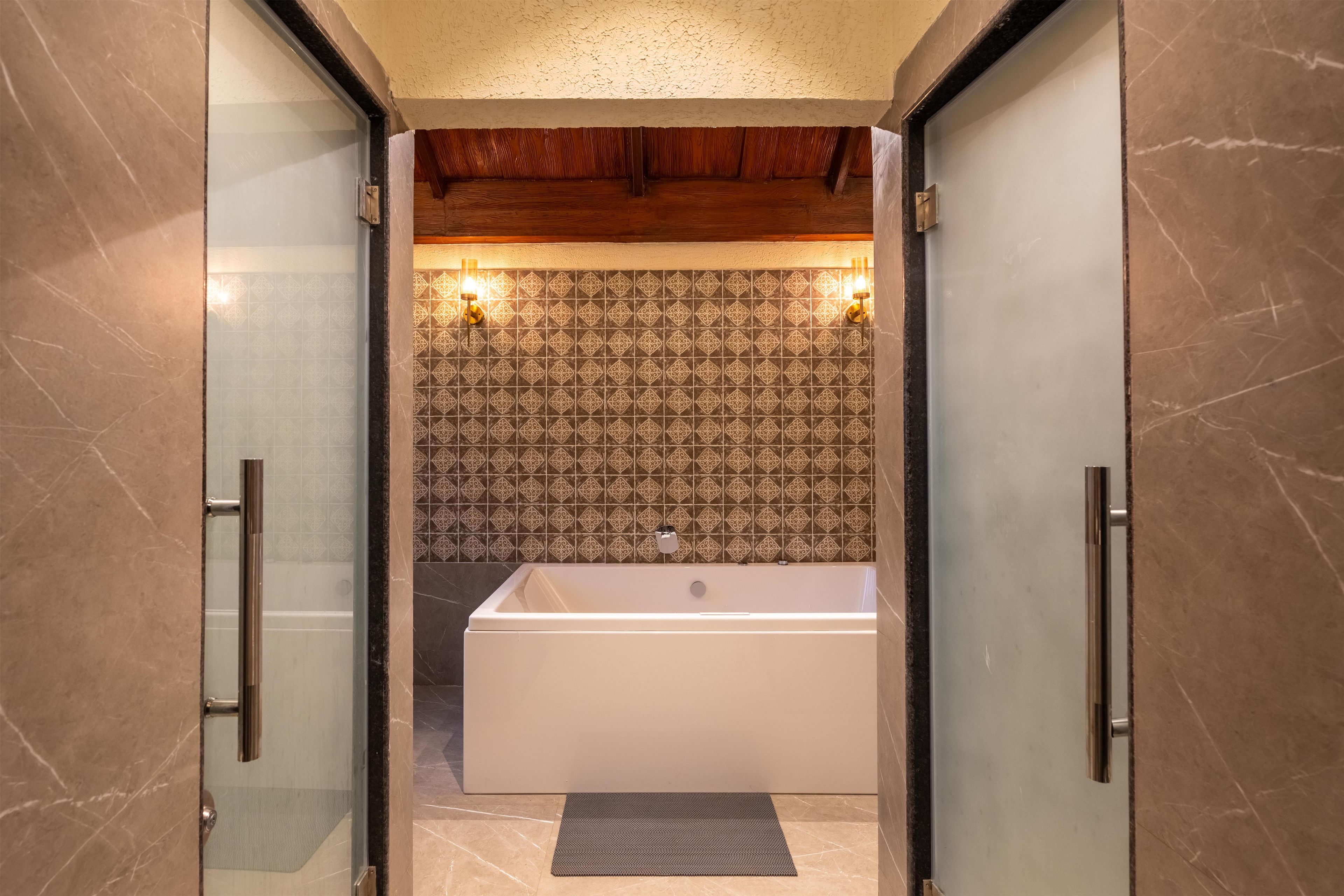 A modern bathroom with a freestanding bathtub, patterned tiles, and a wooden ceiling.