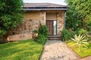 A house with a stone facade, a tiled roof, and a front door.