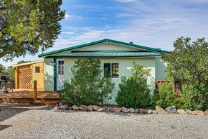 A small, single-story building with a green roof and a front porch. - Colorado Getaway at the base of Sangre de Christos (Fort Garland)