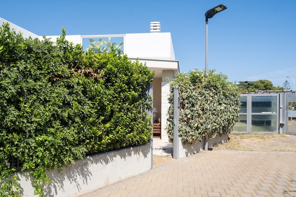 A modern building with a white facade, a green hedge, and a clear sky. - Villa Andrews by Wonderful Italy (Bari)