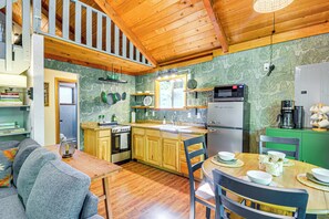 Une cuisine chaleureuse avec des meubles de rangement en bois, une table à manger et un four encastré.