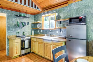 A kitchen with wooden cabinets, a stainless steel refrigerator, a microwave, and a stove. - Lake Cushman Cabin - Hike, Swim, Golf, Relax (Hoodsport)
