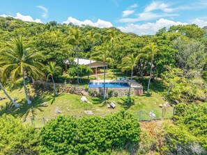 A residential property with a swimming pool, surrounded by lush greenery and palm trees. - Casa en el Risco (Taquillo)