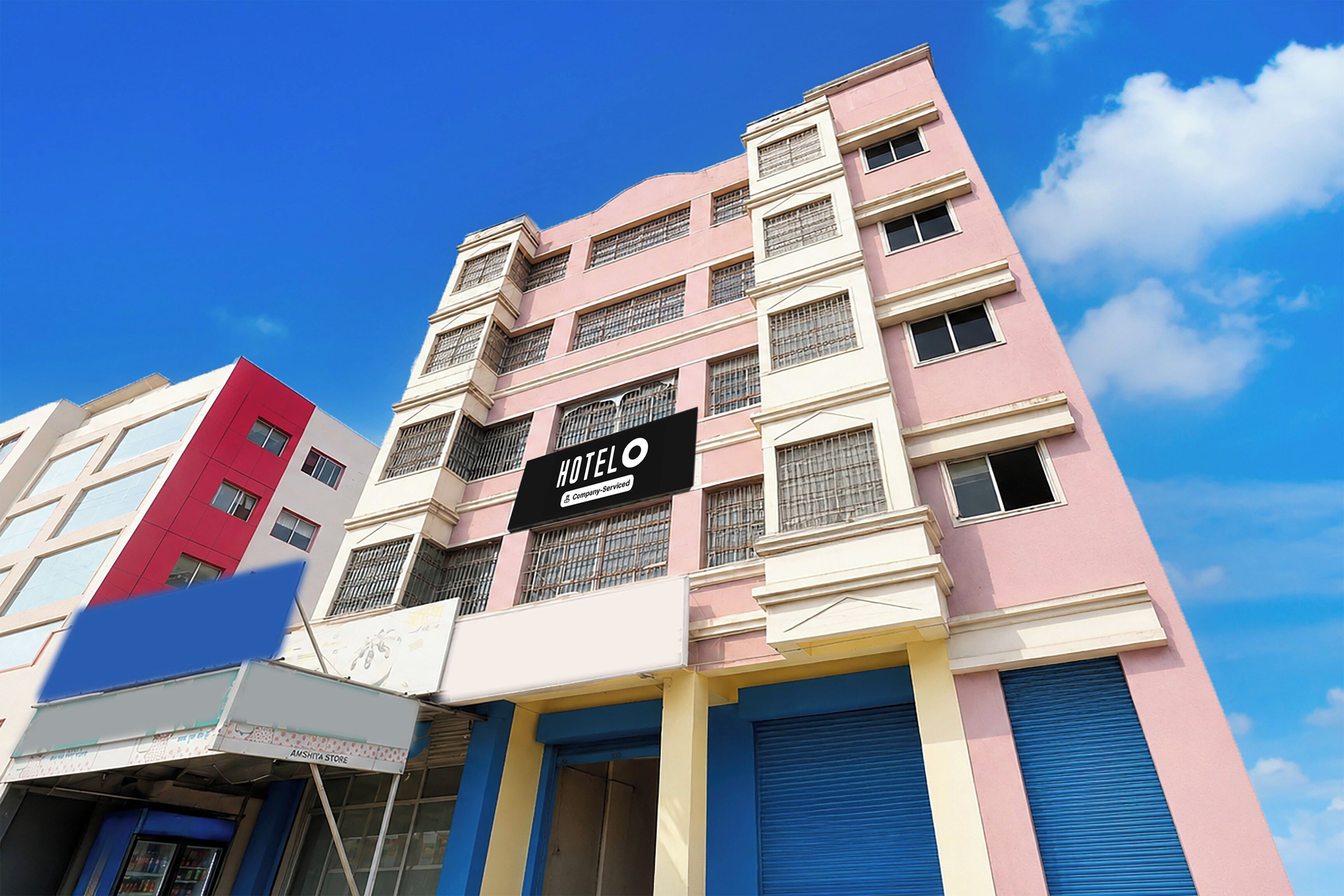 A multi-story hotel building with a sign indicating it is company-serviced.