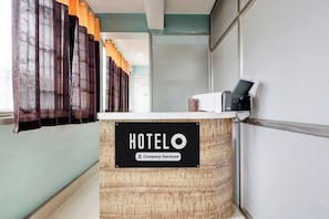 Una recepción de hotel con un cartel que indica servicio de empresa.