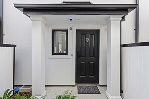 A white building with a black door, a small window, and a number '236' on the door. - Central Stay – 5 Min Walk to Te Pae + FREE Parking (Christchurch)