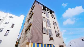 A multi-story hotel building with a sign indicating it is serviced by oyo.