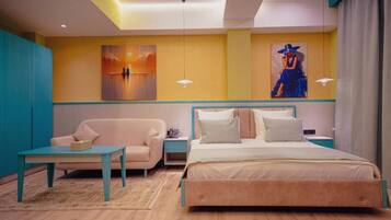 A modern bedroom with a bed, a nightstand, a chair, and artwork on the walls.