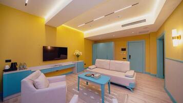 A modern living room with a sofa, coffee table, and a flat-screen TV.