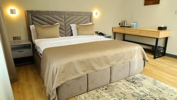 A bedroom with a bed, bedside tables, a desk, and a rug.