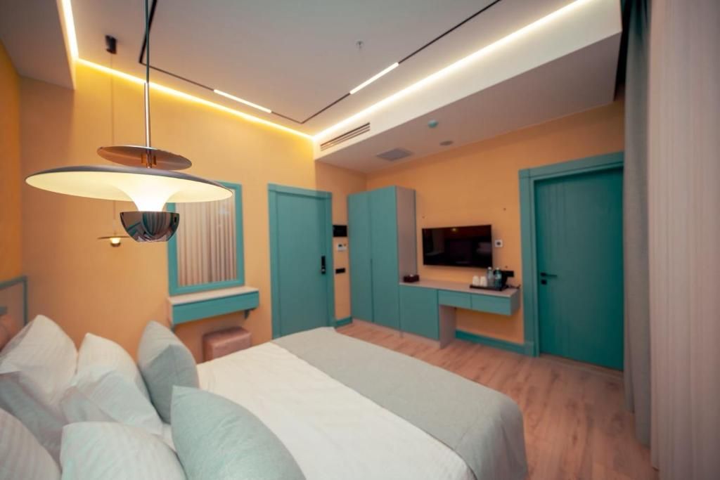 Ein modernes Schlafzimmer mit einem Bett, einem Fernseher und einem Kleiderschrank.