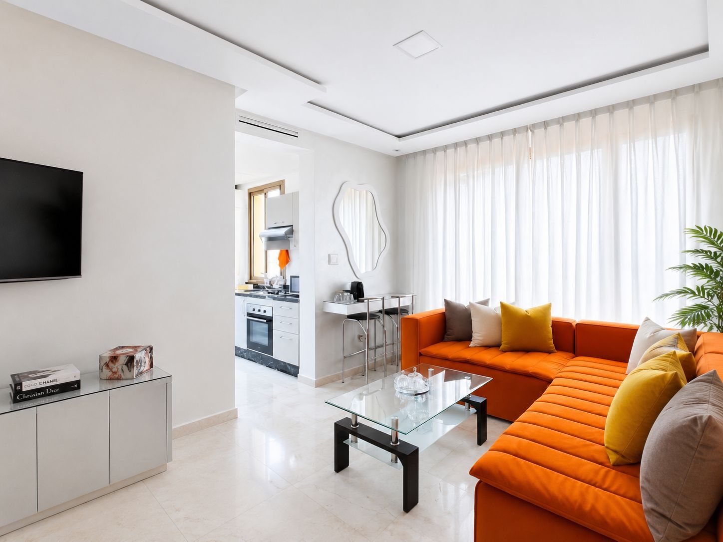A modern living room with a sofa, coffee table, and a TV on a stand.