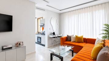 A modern living room with a sofa, coffee table, and a TV on a stand.