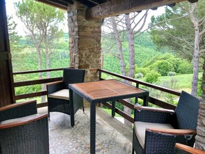 A covered outdoor seating area with wicker furniture and a tiled floor. - Apartment with terrace over Umbrian countryside (Gubbio)