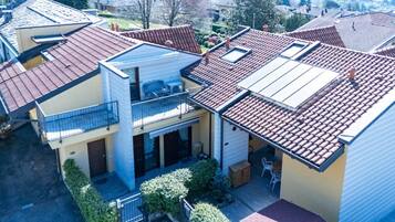 En boligbygning med fladt tag, balkon og lille haveanlæg.