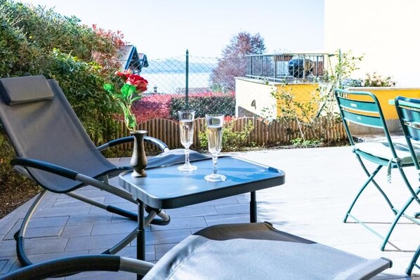 An outdoor patio with a table, two chairs, and two glasses of water.