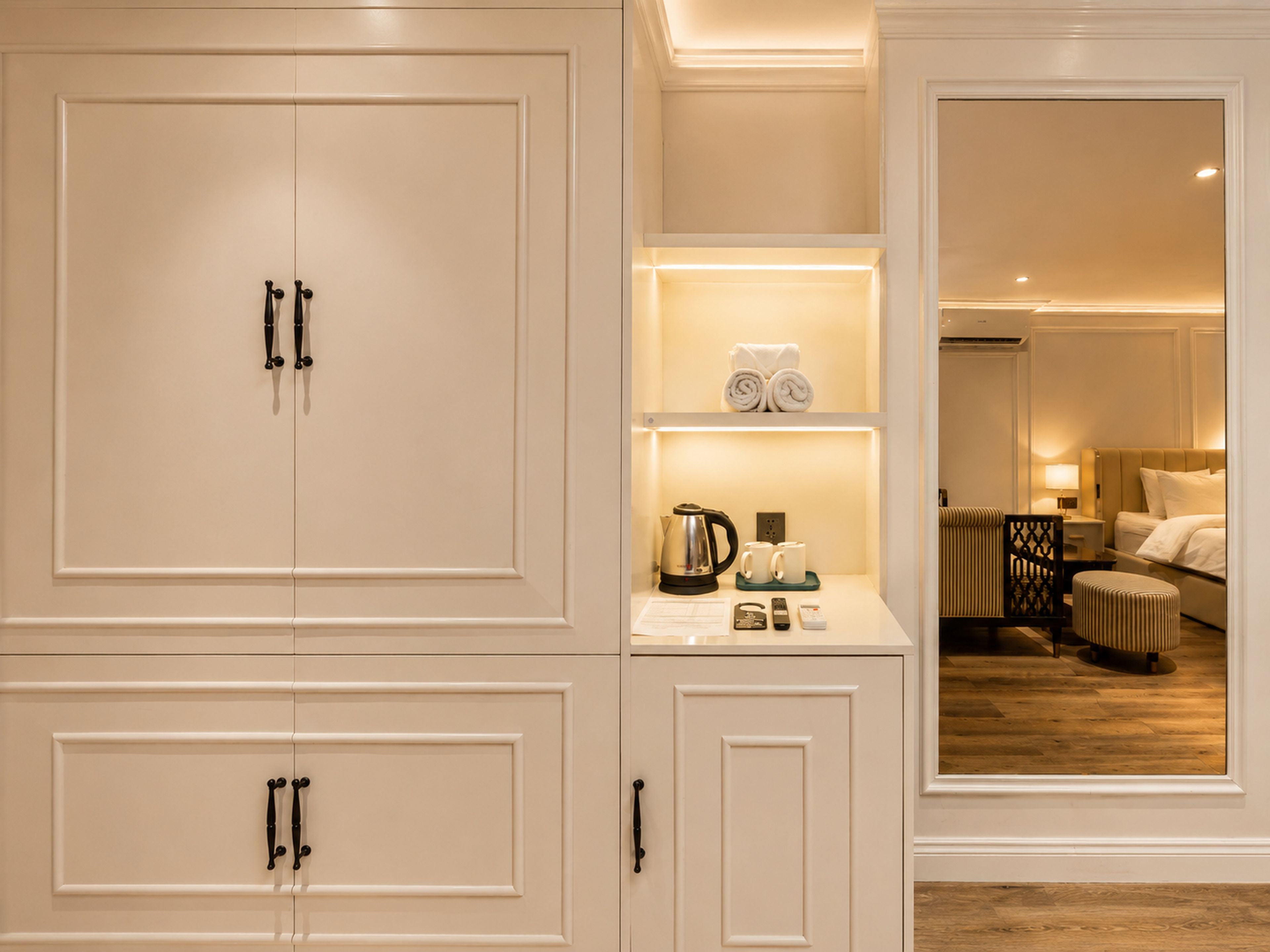 Ein Hotelzimmer mit großem Kleiderschrank, Minibar, Bett und einer Sitzecke.