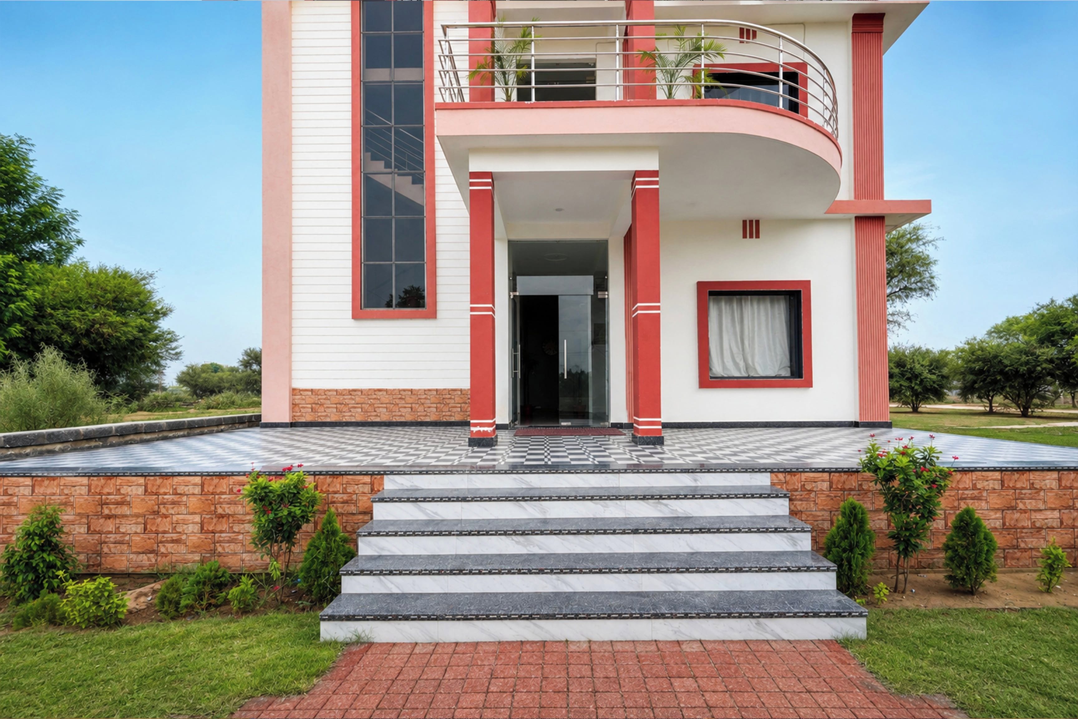 A two-story building with a balcony, a staircase leading to the entrance, and a brick foundation.