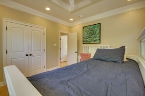 A bedroom with a bed, a door, and a painting on the wall. - 1 Block to Beach! Elegant Family Home in Gulfport (Gulfport)