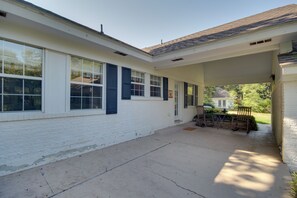 A covered patio area with a concrete floor, white brick walls, and a tiled roof. - 1 Block to Beach! Elegant Family Home in Gulfport (Gulfport)