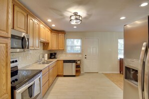 A modern kitchen with wooden cabinets, stainless steel appliances, and a central island.