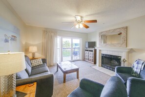A living room with a ceiling fan, a fireplace, and a television. - Resort Perks! Lakefront Unit | Extended Stays (Hot Springs)