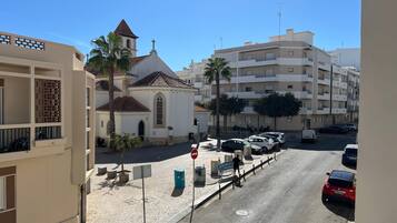 Vista de la calle con una iglesia, coches aparcados y edificios residenciales.