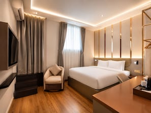 A modern hotel room with a bed, a chair, a desk, and a TV. - KAS Dilly Luxury Hotel (Ho Chi Minh)