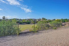 A residential area with houses, a fenced yard, and a clear sky.
