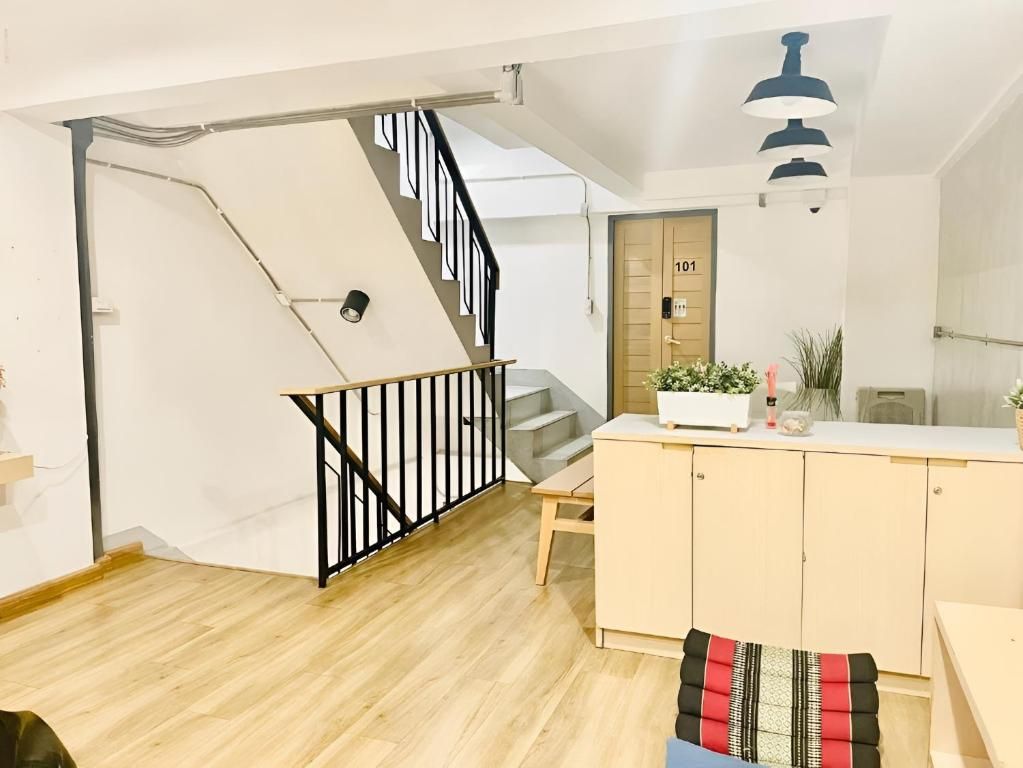Un interior moderno con una escalera, un armario de madera y una puerta marcada con el número 101.