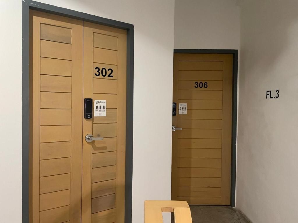 Dos puertas de madera con los números 302 y 306, y un cartel que indica el piso 3.